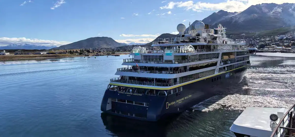World Traveller docked in Ushuaia with mountains and port scenery.
