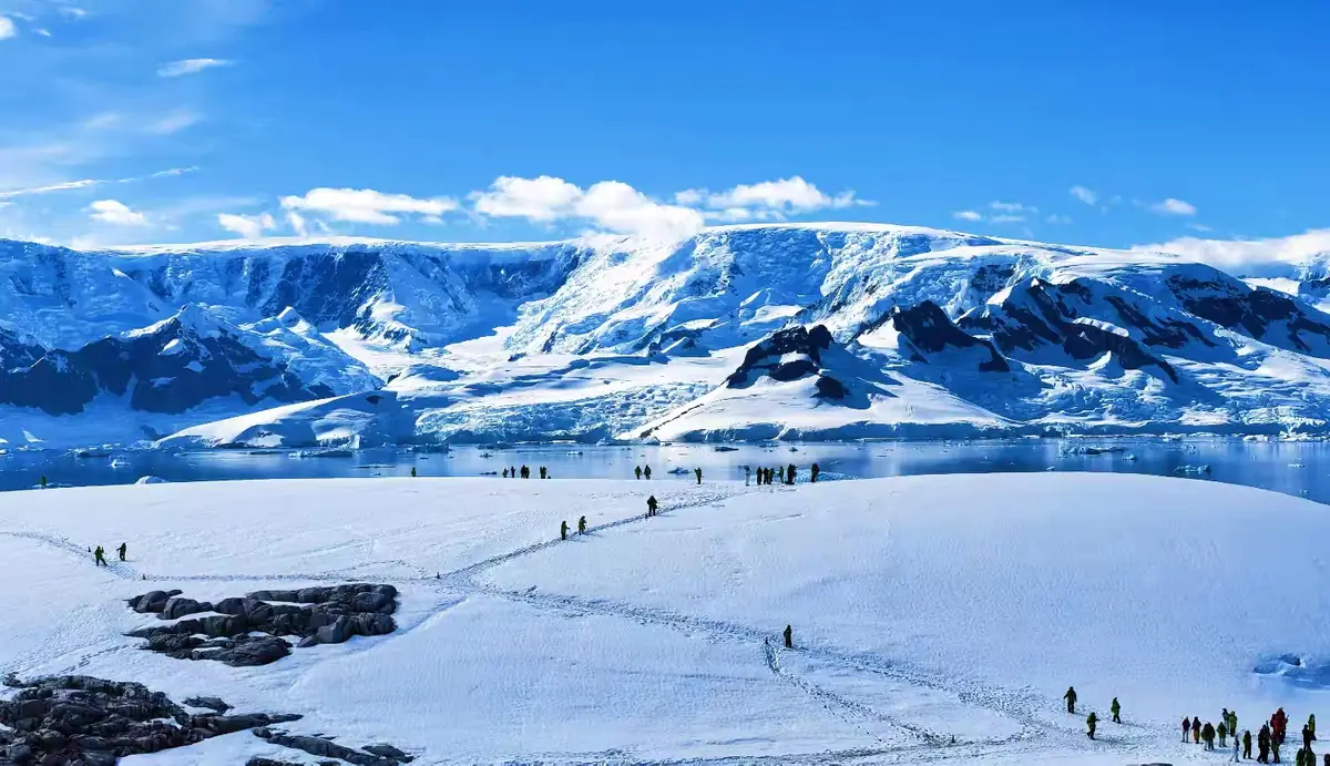 Antarctic mountains, bay scenery and a landing group.