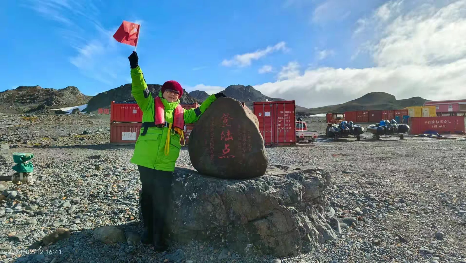 Chen Yanhong waving a flag near Great Wall Station in Antarctica.